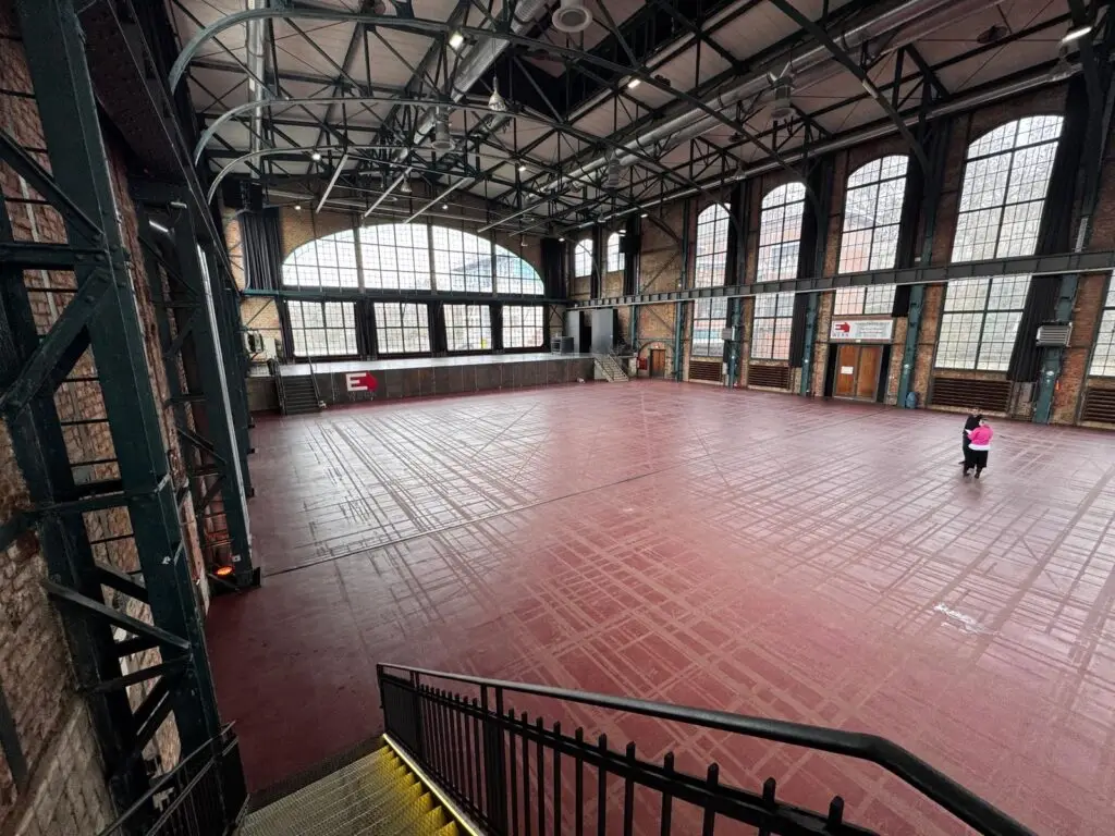 Blick von der Treppe auf die Halle des E WERK Saarbrücken, im Hintergrund ein Beratungsgespräch mit den Messeveranstaltern