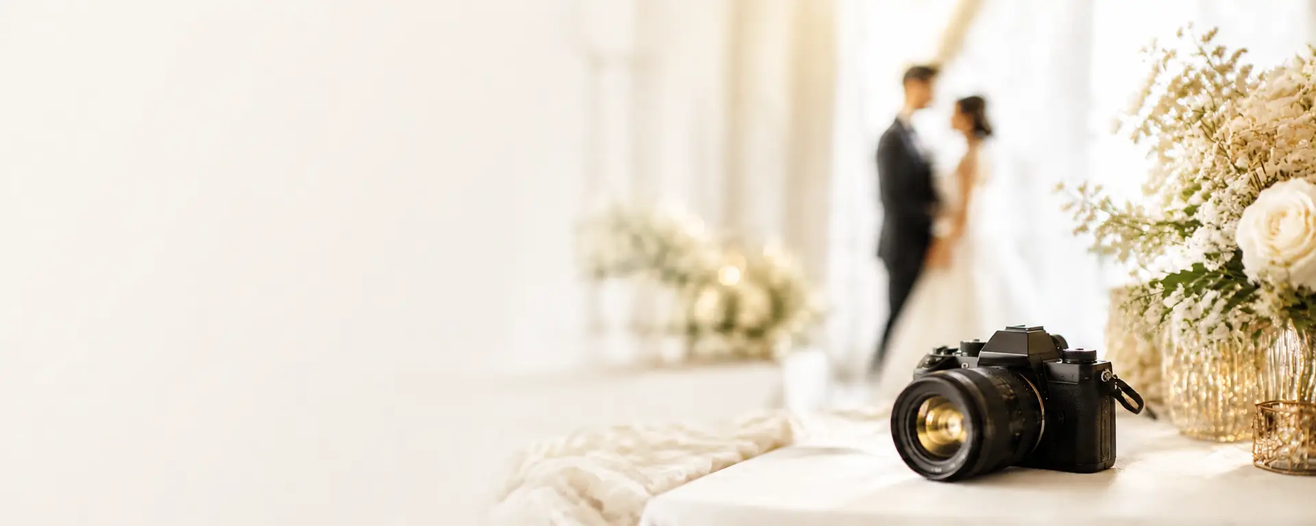 Kamera und Brautpaar im Hintergrund – Header-Bild für Hochzeitsfotografen