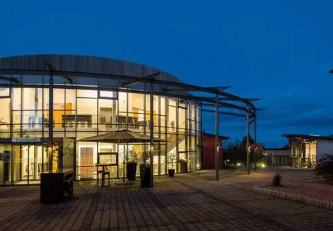 Hauptgebäude vevio Hotel & Events bei Abenddämmerung